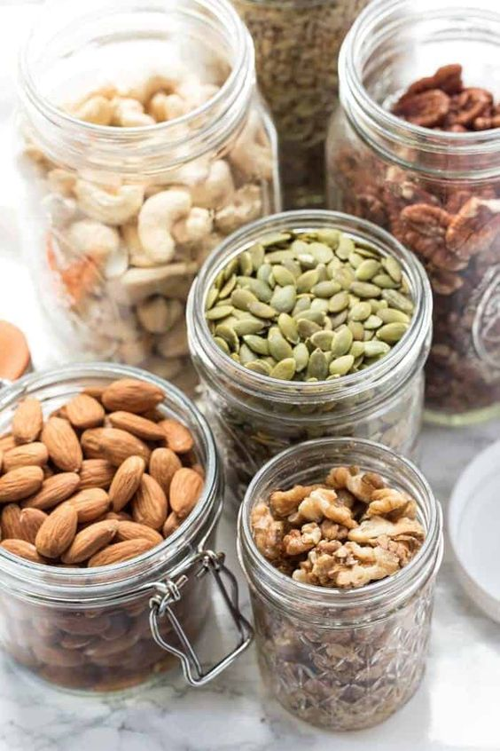 Castanhas, sementes e frutas secas em potes de vidro